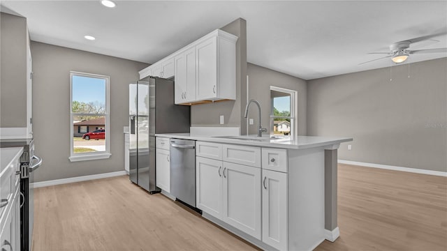 kitchen featuring a sink, plenty of natural light, appliances with stainless steel finishes, and white cabinets