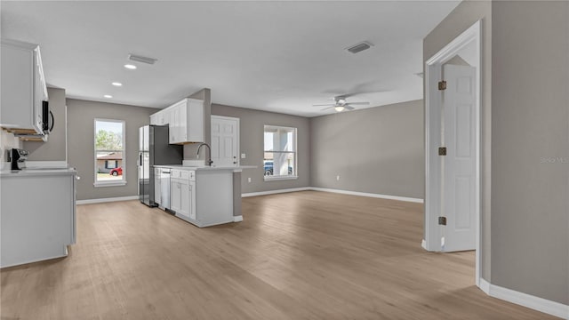 kitchen with a healthy amount of sunlight, stainless steel appliances, light countertops, and light wood-style floors