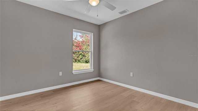 spare room featuring visible vents, baseboards, light wood-style floors, and a ceiling fan