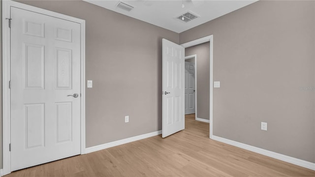 unfurnished bedroom featuring light wood-style floors, visible vents, and baseboards