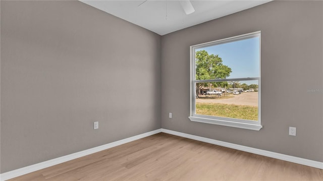 spare room with wood finished floors, baseboards, and ceiling fan