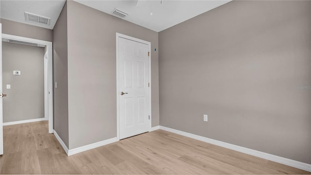 unfurnished bedroom featuring visible vents, light wood-type flooring, and baseboards