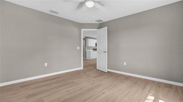 spare room featuring visible vents, ceiling fan, baseboards, and light wood-style floors