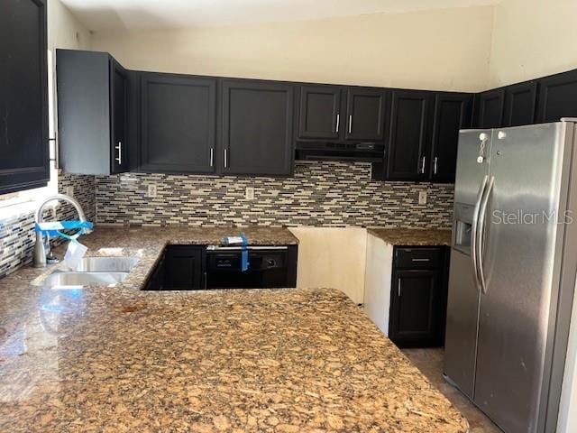 kitchen featuring stainless steel refrigerator with ice dispenser, a sink, tasteful backsplash, range hood, and light stone countertops