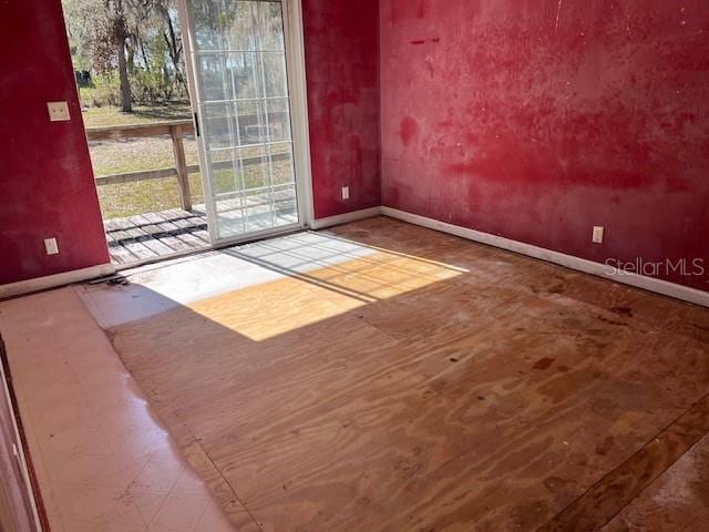 unfurnished room with baseboards