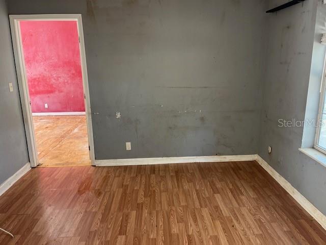 unfurnished room featuring baseboards and wood finished floors