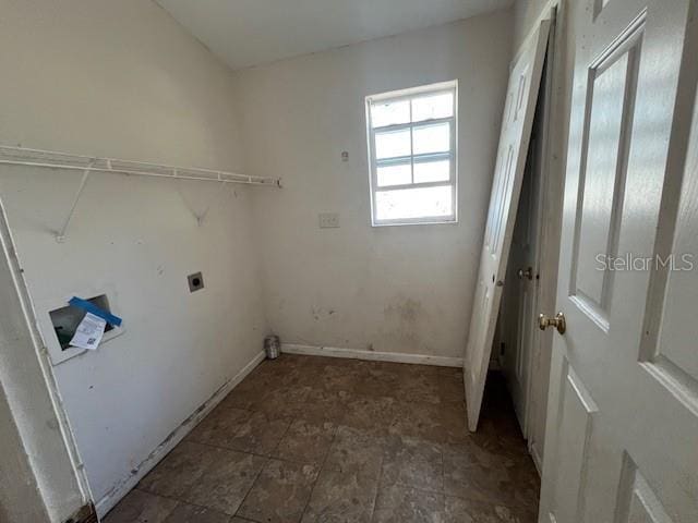 clothes washing area with baseboards, hookup for an electric dryer, and laundry area