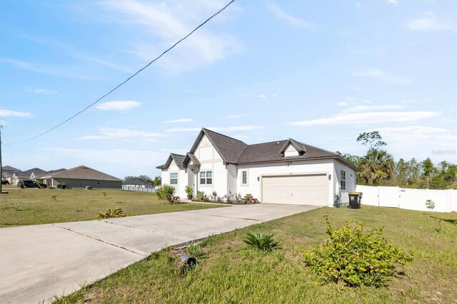 747 Fraser Ct, Kissimmee, FL 34759 - view of front of property featuring fence, stucco siding, an attached garage, driveway, and a front yard