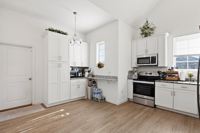 747 Fraser Ct, Kissimmee, FL 34759 - kitchen featuring white cabinets, light wood-type flooring, baseboards, appliances with stainless steel finishes, and hanging light fixtures