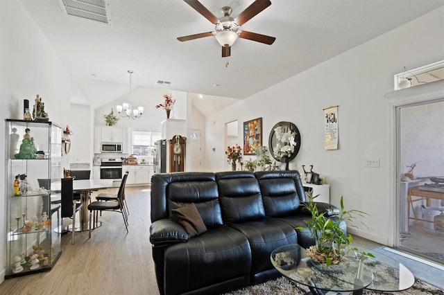 747 Fraser Ct, Kissimmee, FL 34759 - living area featuring light wood-type flooring, visible vents, high vaulted ceiling, and ceiling fan with notable chandelier