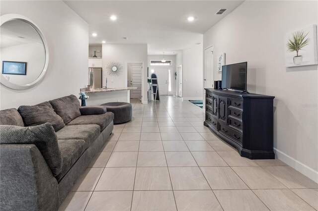 living room with light tile patterned floors, recessed lighting, visible vents, and baseboards