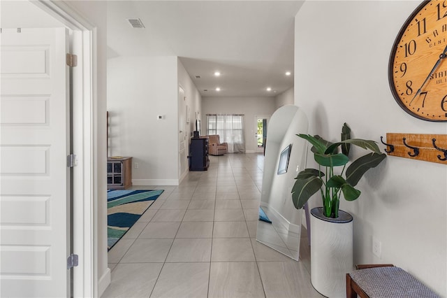 hall with light tile patterned floors, visible vents, baseboards, and recessed lighting