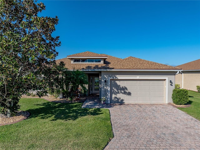 view of front facade featuring a front yard, decorative driveway, a garage, and stucco siding