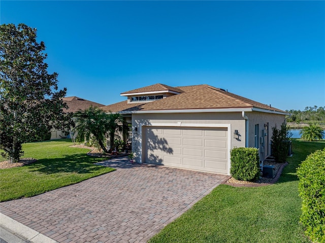 view of front of home featuring stucco siding, a front lawn, decorative driveway, an attached garage, and a shingled roof