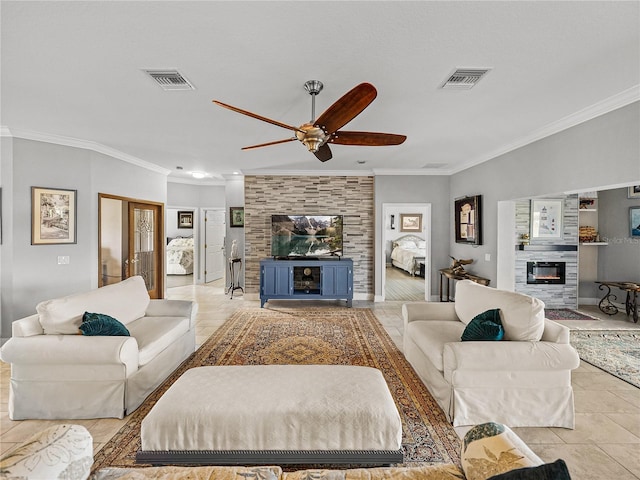 living room with visible vents, ornamental molding, ceiling fan, and a glass covered fireplace