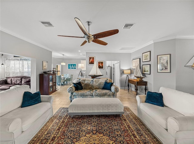 living room with visible vents, a healthy amount of sunlight, crown molding, and a ceiling fan