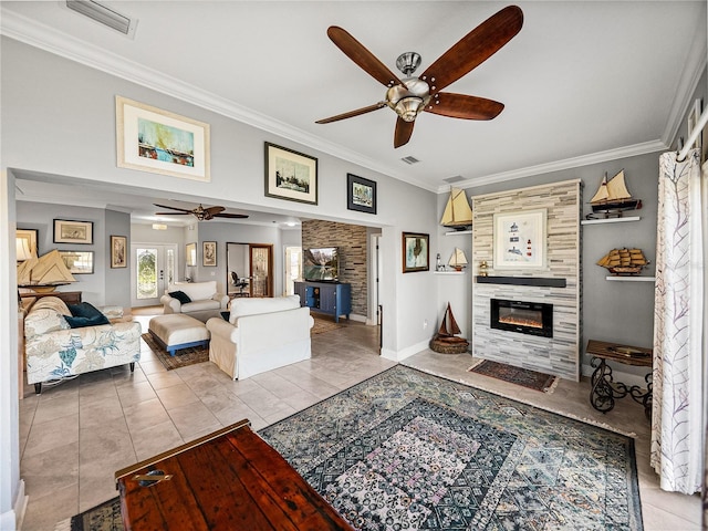 living area featuring visible vents, a tiled fireplace, a ceiling fan, and crown molding