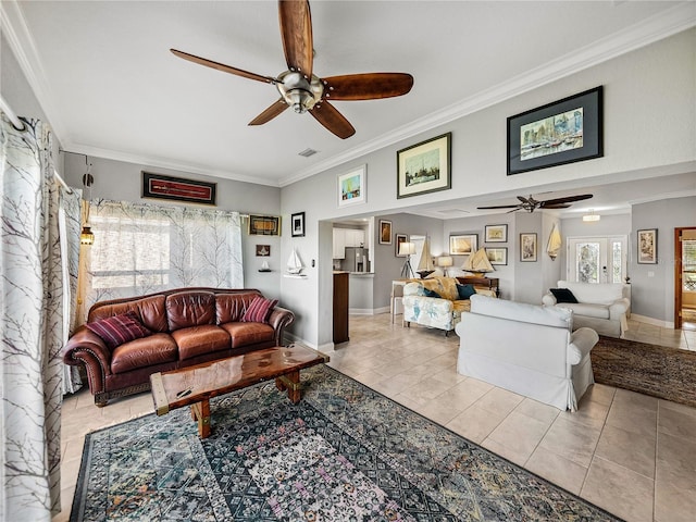 living area with baseboards, ceiling fan, crown molding, and tile patterned flooring