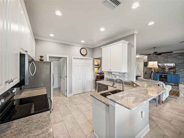 kitchen with a sink, visible vents, appliances with stainless steel finishes, and white cabinetry