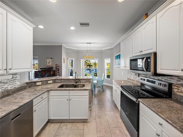 kitchen featuring visible vents, a peninsula, a sink, appliances with stainless steel finishes, and white cabinetry