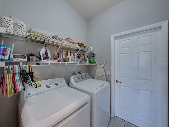 clothes washing area with light tile patterned floors, laundry area, and washing machine and dryer