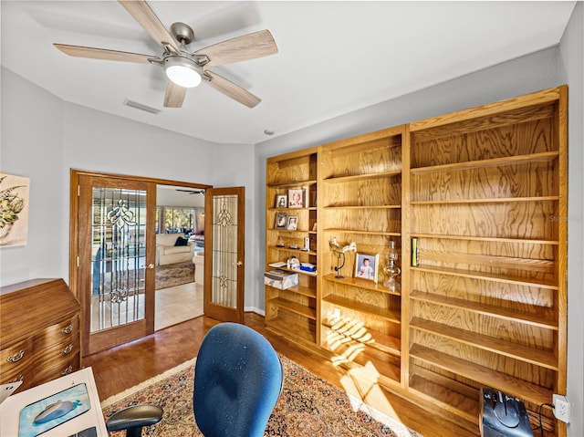 office area with wood finished floors, visible vents, french doors, and ceiling fan