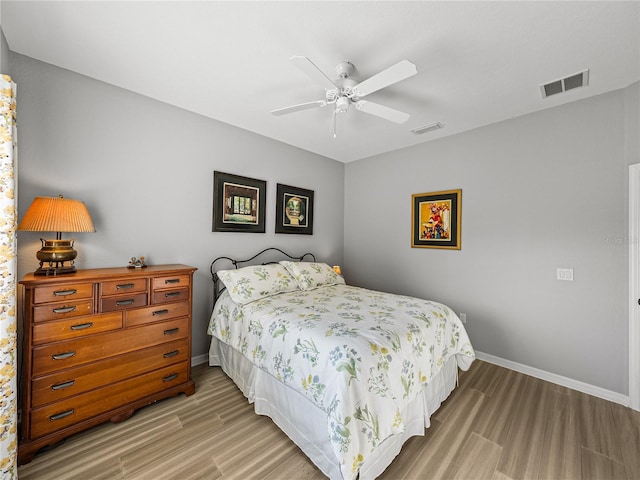 bedroom featuring visible vents, baseboards, and light wood finished floors