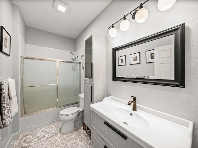 full bathroom featuring bath / shower combo with glass door, toilet, vanity, and tile patterned flooring