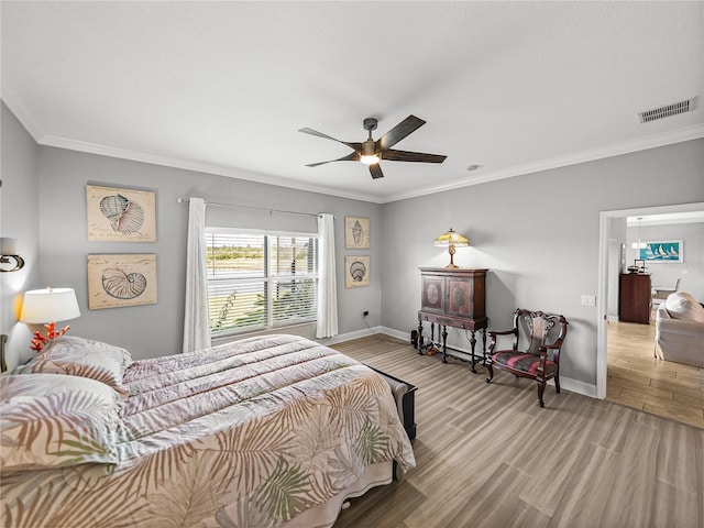 bedroom with visible vents, wood finished floors, and baseboards