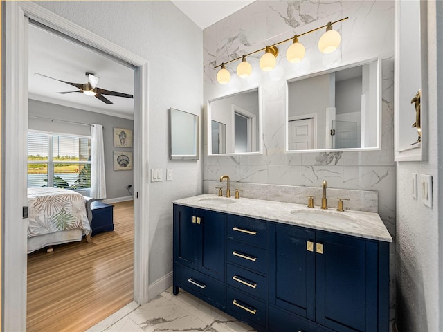 ensuite bathroom featuring double vanity, marble finish floor, ensuite bath, and a sink