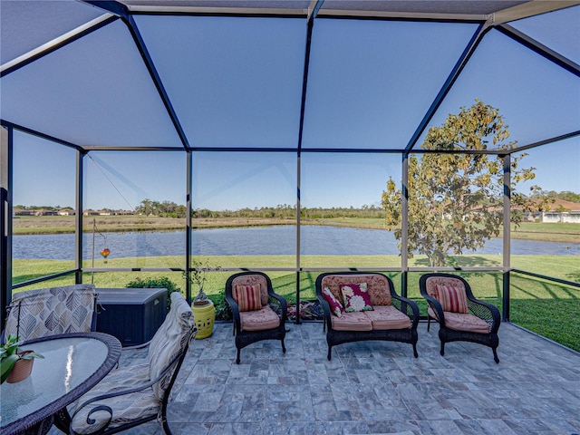 view of patio featuring a lanai and a water view