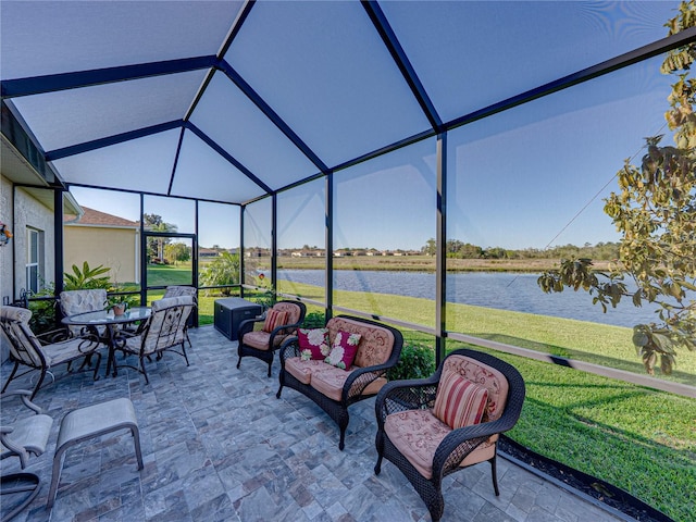 exterior space with glass enclosure, a water view, and outdoor lounge area