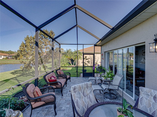 view of patio / terrace featuring a lanai, an outdoor hangout area, and a water view