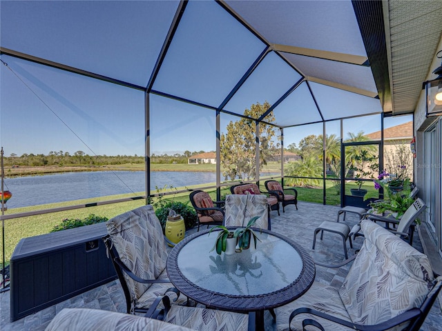 view of patio / terrace with glass enclosure, outdoor dining area, and a water view