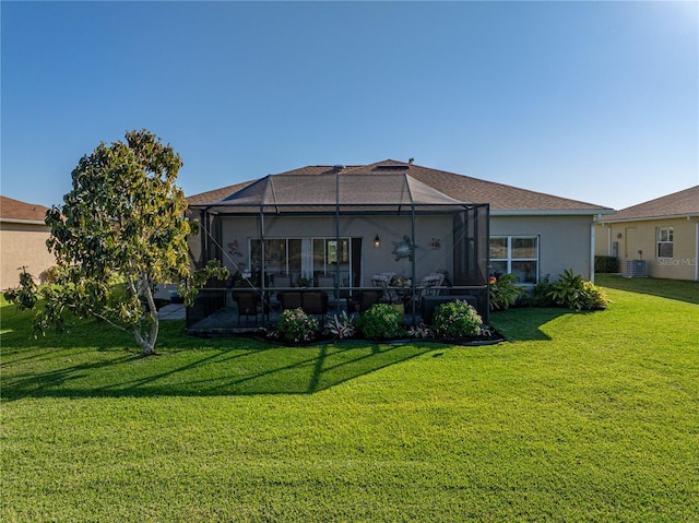 back of house featuring glass enclosure, cooling unit, a lawn, and stucco siding