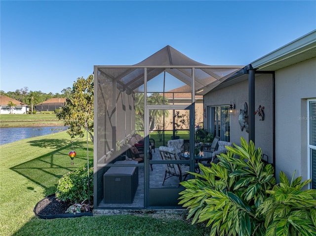 view of patio featuring glass enclosure and a water view