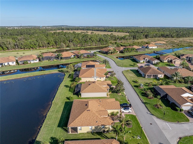 birds eye view of property featuring a residential view, a water view, and a wooded view