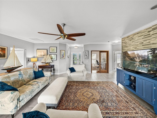 living area with light tile patterned floors, visible vents, baseboards, ceiling fan, and crown molding