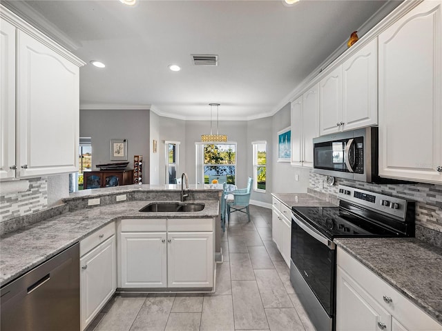 kitchen with visible vents, a peninsula, a sink, stainless steel appliances, and white cabinetry