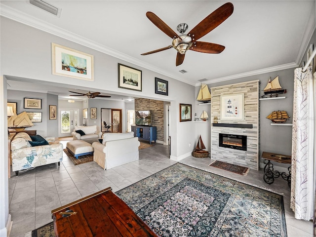 tiled living room featuring visible vents, ceiling fan, crown molding, and a tiled fireplace