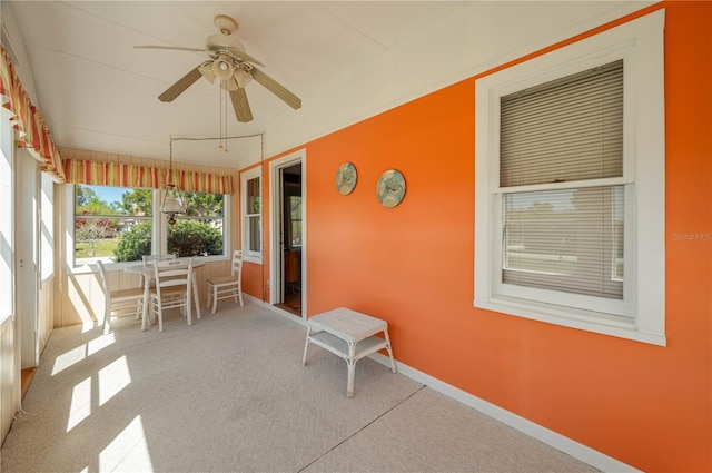 unfurnished sunroom featuring a ceiling fan