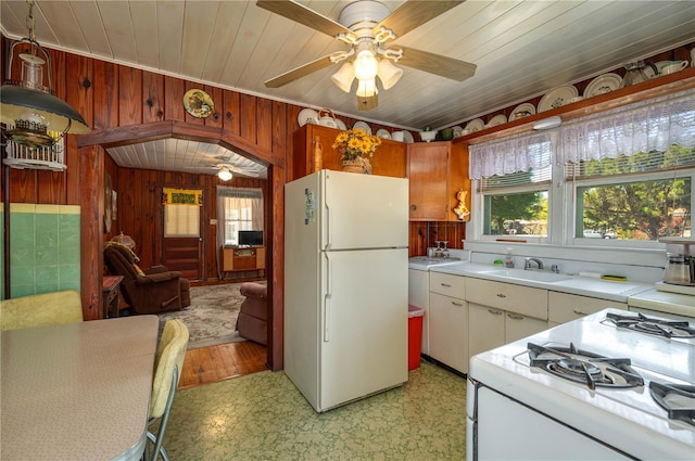 kitchen featuring a sink, white appliances, a ceiling fan, and light countertops