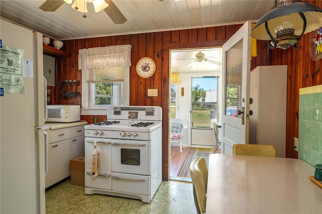 kitchen with white appliances, wooden walls, wood ceiling, and ceiling fan