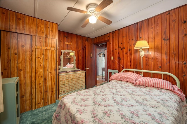 carpeted bedroom featuring ceiling fan and wood walls
