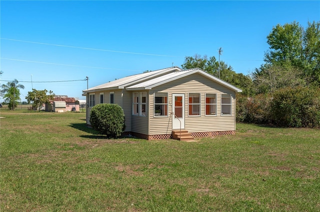 back of house featuring a yard and entry steps