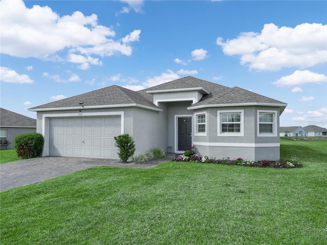 view of front of home featuring stucco siding, decorative driveway, an attached garage, a shingled roof, and a front yard