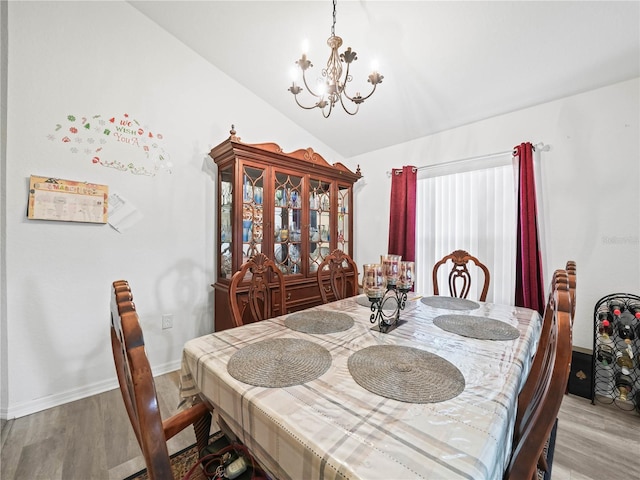 dining room with an inviting chandelier, light wood-style flooring, baseboards, and lofted ceiling