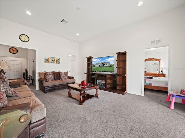 carpeted living room with visible vents, recessed lighting, and a towering ceiling