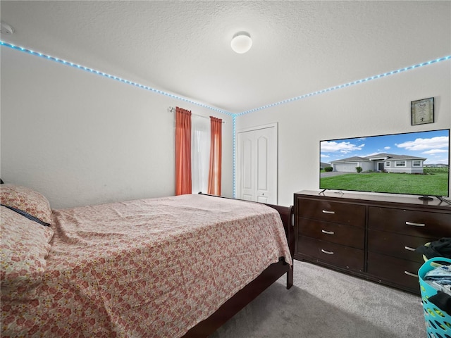 carpeted bedroom featuring a closet and a textured ceiling