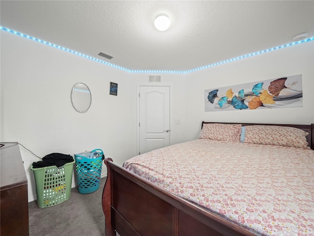 bedroom featuring visible vents, a textured ceiling, and carpet floors